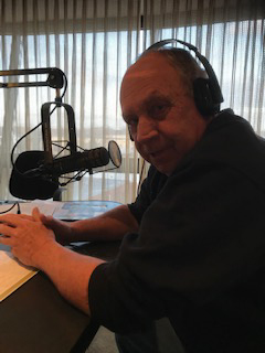 A man with headphones on in front of a microphone.